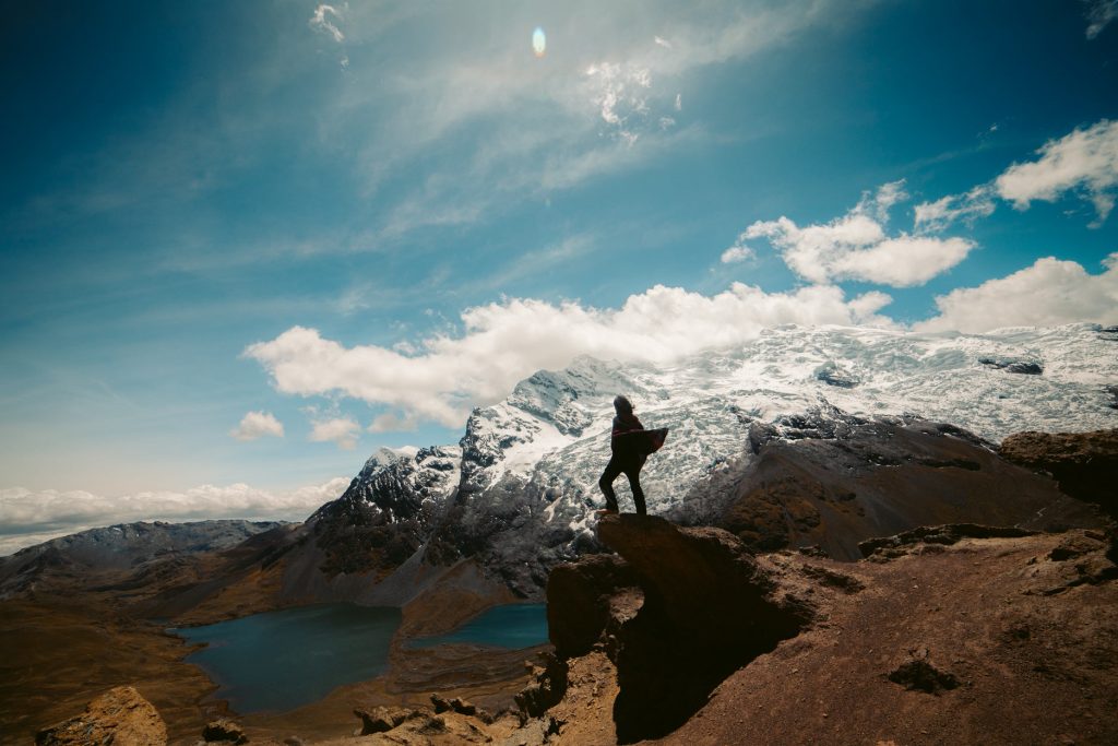 A tourist wearing an Andean poncho in front of the sacred mountain of Ausangate