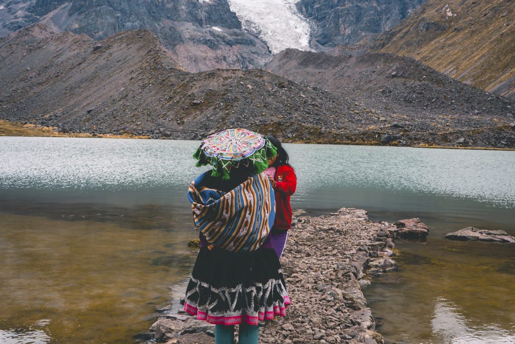 Andean woman in front of glacial lake