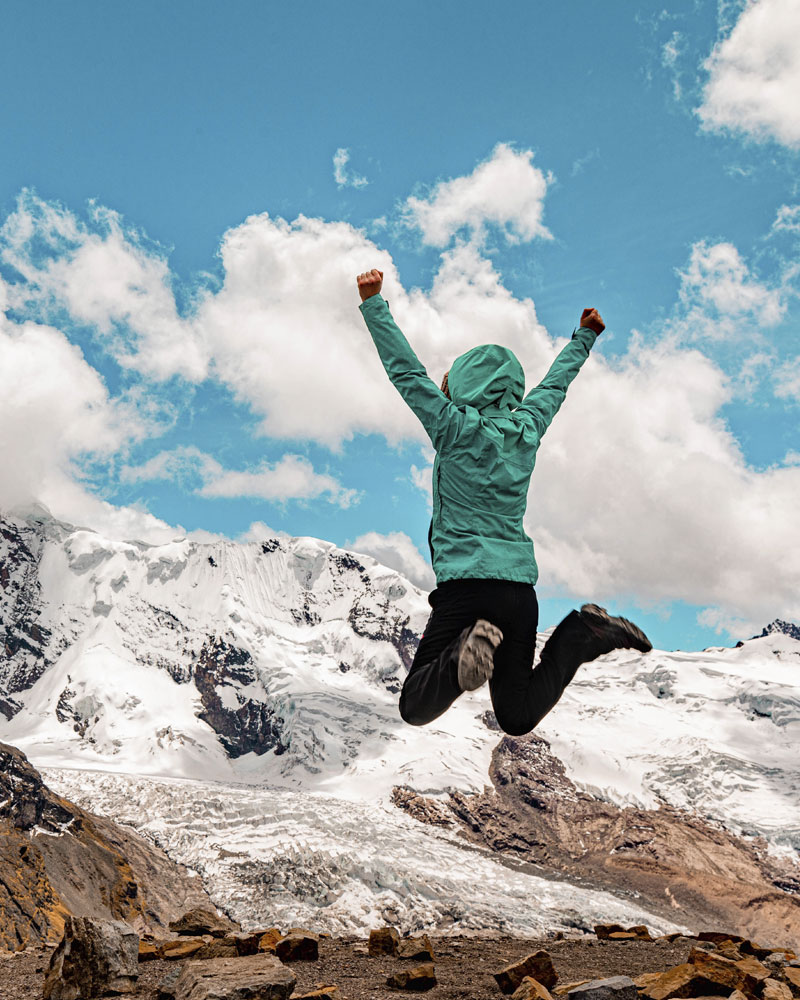 Tourist jumping with joy at the Palomani Pass.