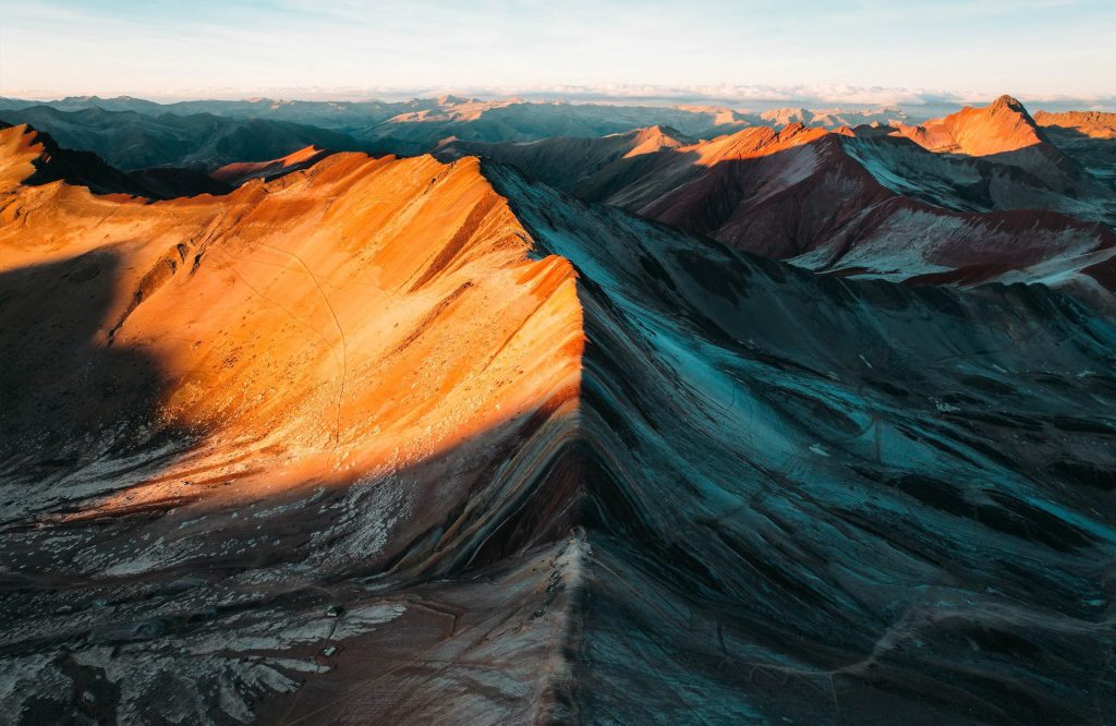 The sun rising over Rainbow Mountain