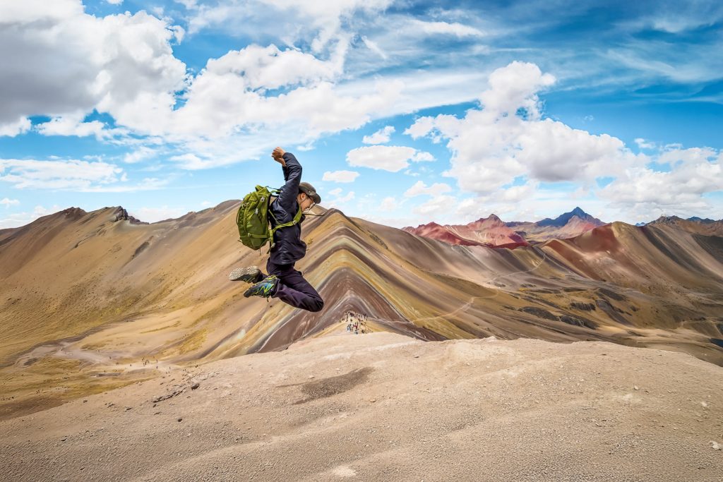 Tourist jumpingi nto the air at Vinicunca, Rainbow Mountain